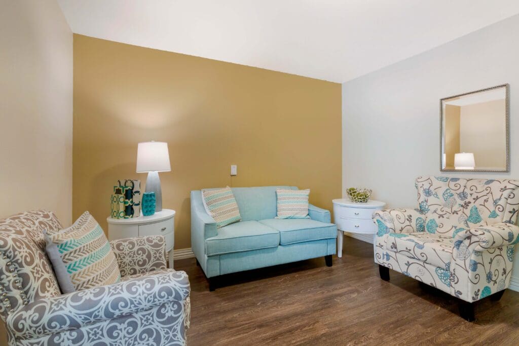 303A2198 - Inspirations of Peoria Resident's living room with comfortable furniture and warm paint colors at Inspirations of Peoria senior living.