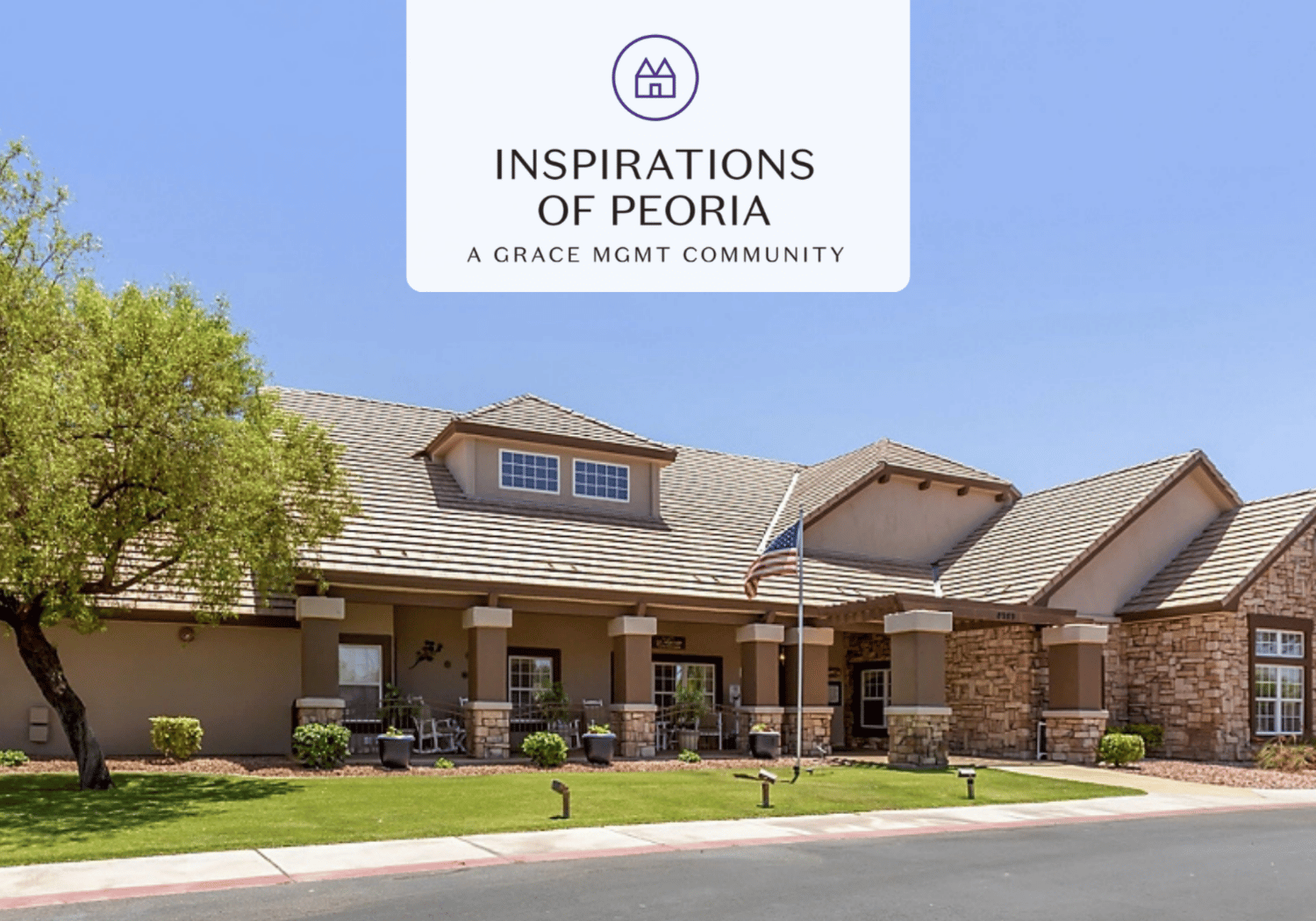 Exterior view of Inspirations of Peoria, a Grace Mgmt community, with a beige building, stone columns, and a manicured lawn.